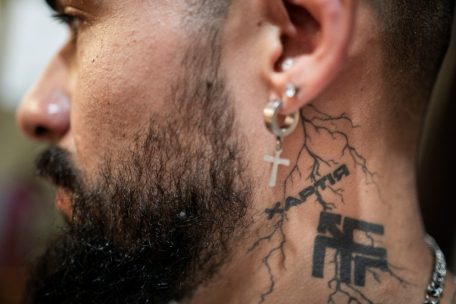 Tätowierung auf dem Hals eines kolumbianischen Kämpfers. Die Tätowierung zeigt Namen und Wappen der Chartija-Brigade.