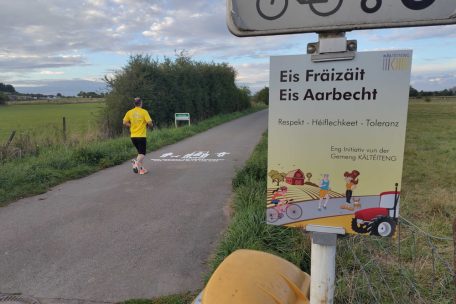 Ein Schild und ein gesprühtes Piktogramm rufen zu mehr Respekt auf dem Feldweg auf