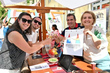 Elena Vasilica und Alexandru Dan (r.) beim Anstoßen mit Mitgliedern der rumänischen Gemeinschaft – der Wein kommt selbstverständlich aus Rumänien. „Noroc!“ (Prost!).