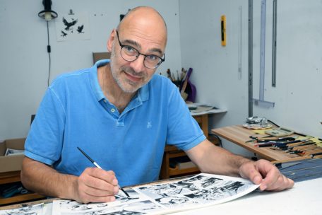 Marc Angel (1960) arbeitet als freischaffender Grafiker, Buchillustrator und Verleger sowie als Künstler. Er veröffentlicht hauptsächlich Comics und Graphic Novels für Erwachsene und Jugendliche. In seinem Werk befasst er sich vor allem mit Geschichte und Legenden. 2020 erhielt er für „Zeeechen“ – in Zusammenarbeit mit dem Autor Samuel Hamen entstanden – den „Lëtzebuerger Buchpräis“. Das Buch erzählt vom Erwachsenwerden im Luxemburg der 1990/2000er-Jahre. Weitere Informationen zu Angel gibt es auf autorenlexikon.lu und insitu.blog.