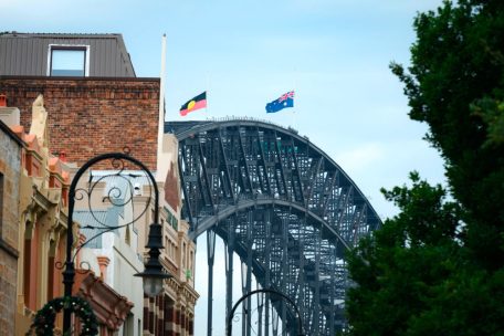 Die australische und die Aborigine-Flagge wehen am 21. Dezember 2025 auf der Sydney Harbour Bridge auf Halbmast, als Teil eines nationalen Gedenktages zu Ehren der Opfer des Terroranschlags am Bondi Beach