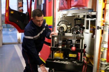 Feuerwehrmann überprüft vor Nachteinsatz Funkgeräte und Atemschutzgerät für sicheren Materialcheck